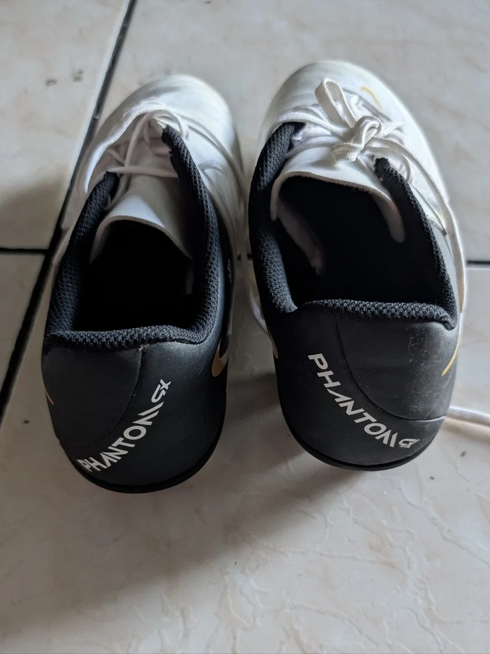 Nike White and Black Soccer Cleats with Gold Swoosh